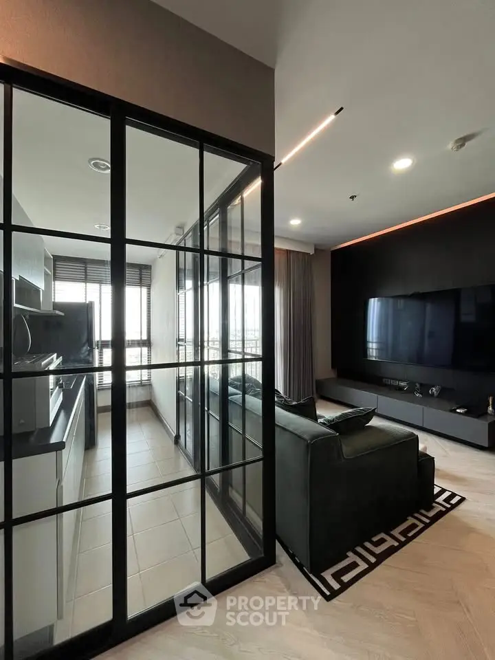 Modern living room with glass partition and sleek kitchen design