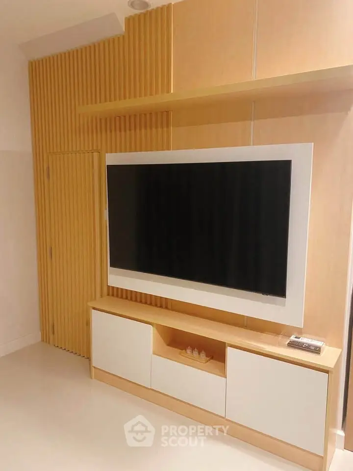 Modern living room with sleek TV unit and stylish wooden paneling.