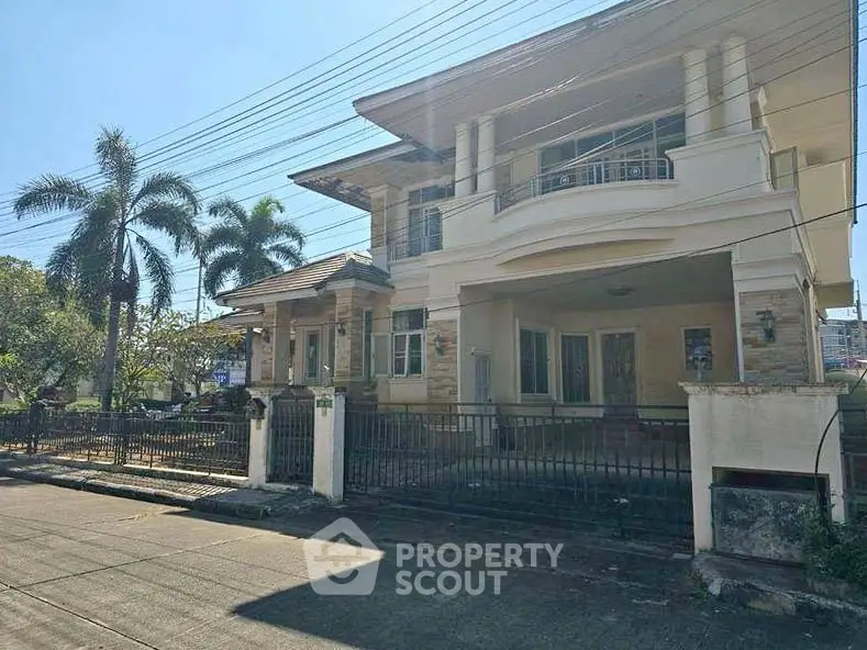 Stunning two-story house with spacious balcony and lush palm trees, perfect for family living.