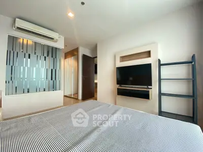 Modern bedroom with air conditioning and wall-mounted TV in a stylish apartment.