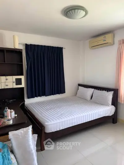 Cozy bedroom with air conditioning and natural light, perfect for relaxation.