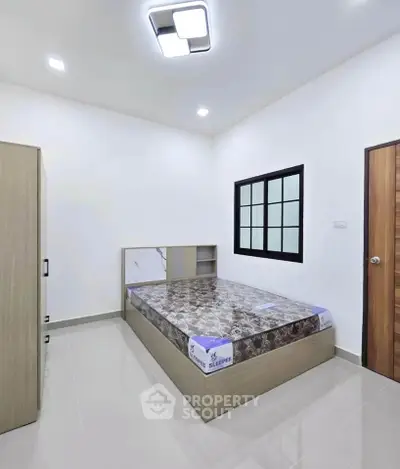 Modern minimalist bedroom with sleek design and ample natural light.