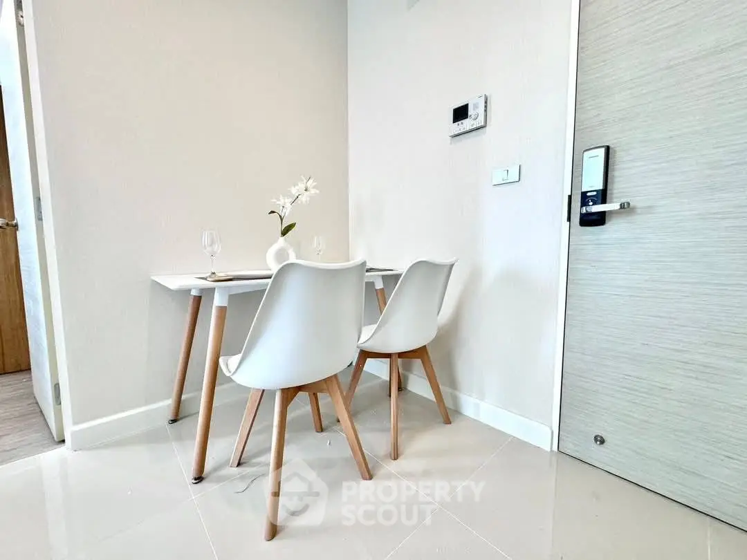 Modern minimalist dining area with sleek white furniture and elegant decor.