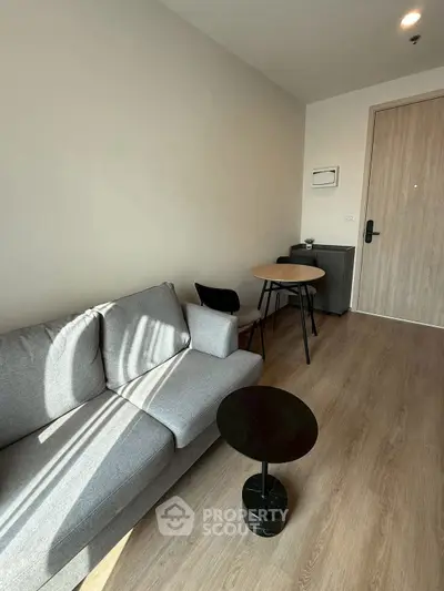 Modern living room with cozy gray sofa and stylish round table in a bright apartment.
