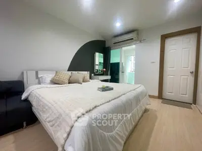 Spacious bedroom with modern decor and cozy ambiance, featuring a comfortable bed and stylish furnishings.