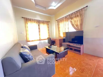 Cozy living room with modern furniture and large TV, perfect for relaxation.