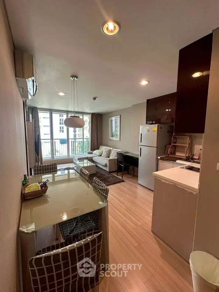Modern open-layout living room and kitchen with stylish decor and natural light.