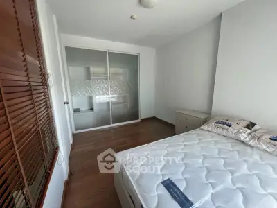 Spacious bedroom with wooden flooring and built-in wardrobe, perfect for modern living.