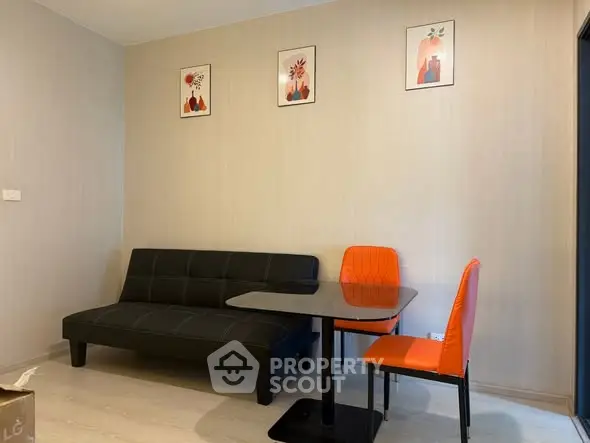 Modern living room with stylish black sofa and vibrant orange chairs