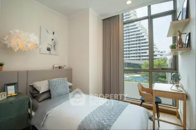 Modern bedroom with large window and stylish decor overlooking a scenic view.