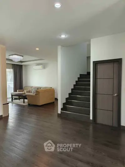 Spacious living room with elegant staircase and modern decor