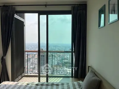 Stunning bedroom with city view and balcony access in modern high-rise apartment.