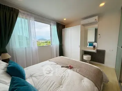 Cozy bedroom with scenic view, featuring modern decor and ample natural light.