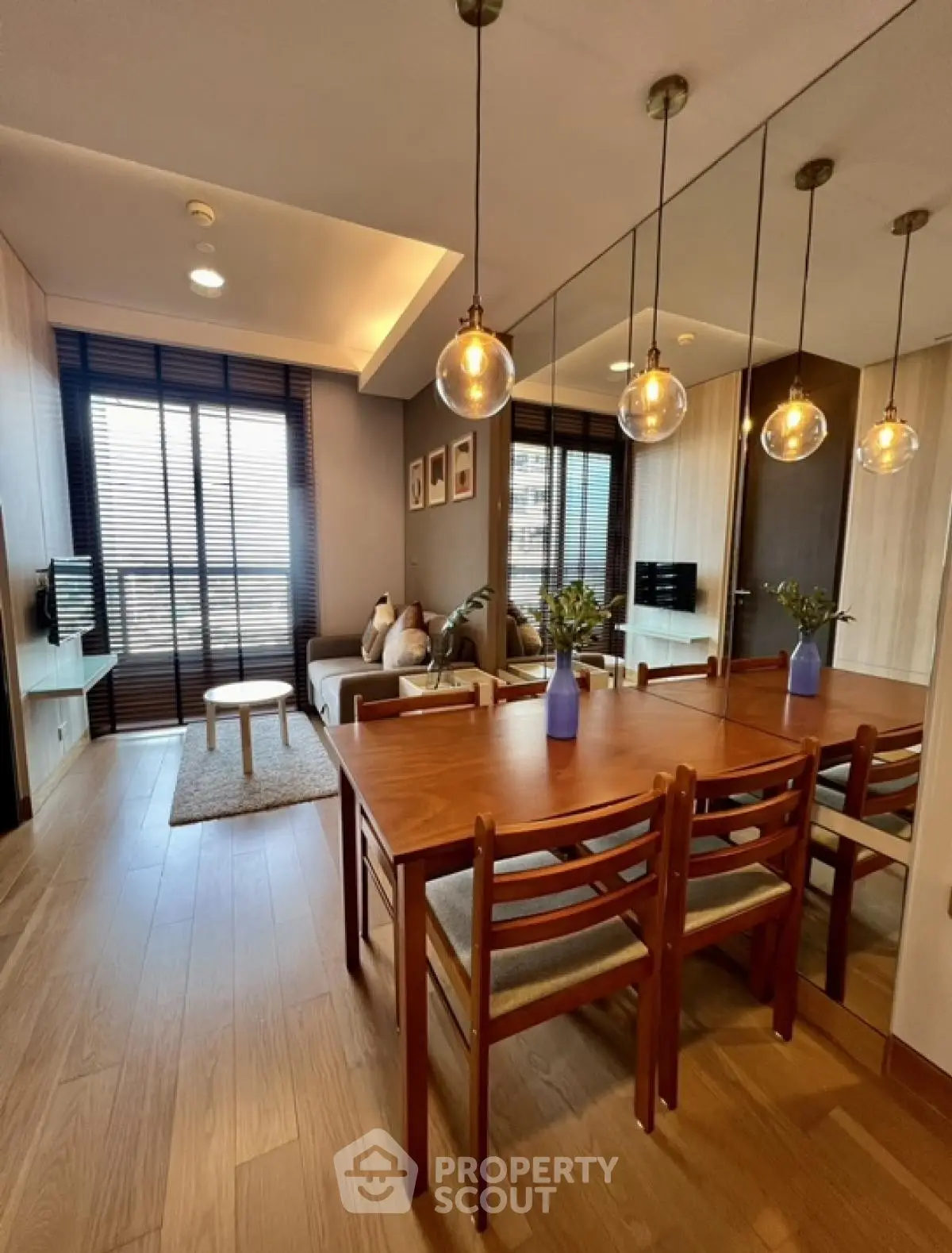 Modern living room with dining area and stylish lighting in a cozy apartment.