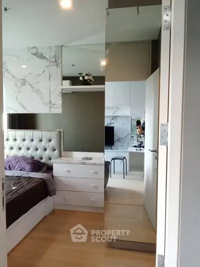 Modern bedroom with elegant decor and mirrored wardrobe in a stylish apartment.