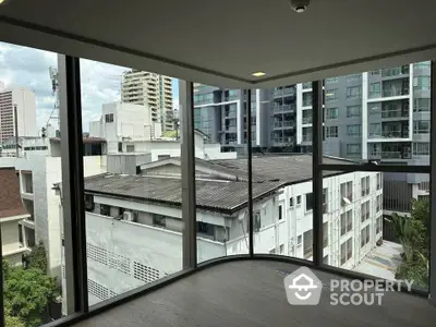 Modern corner unit with floor-to-ceiling windows offering urban city views.