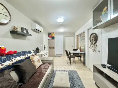 Cozy living room with modern decor and dining area, featuring neutral tones and stylish furnishings.