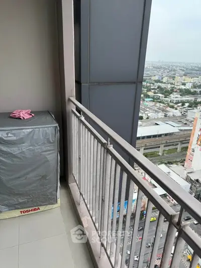 High-rise balcony with city view and Toshiba appliance, ideal for urban living.