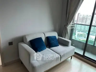 Cozy living room with modern sofa and city view balcony, perfect for urban living.