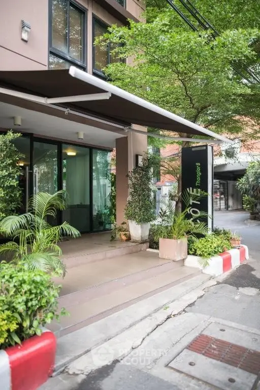 Modern building entrance with lush greenery and sleek design