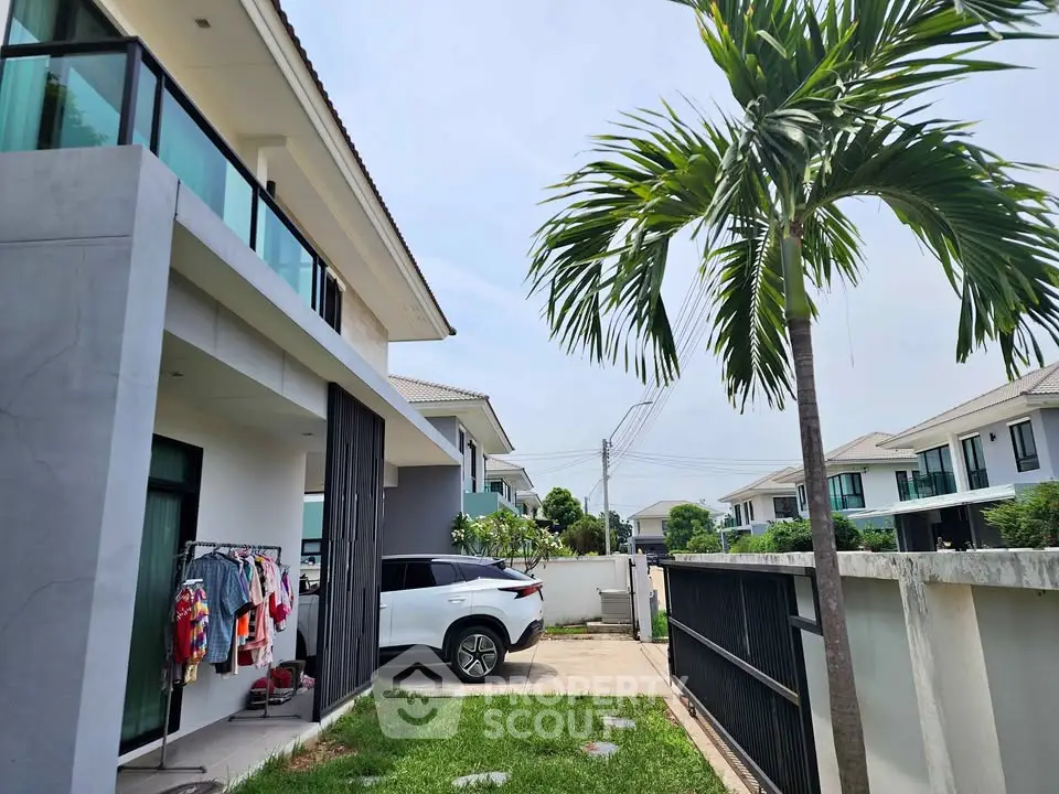 Modern suburban home with carport and lush garden, showcasing contemporary architecture and spacious outdoor area.