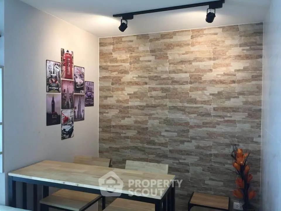 Modern dining area with stylish stone accent wall and wooden table set.