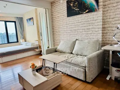 Modern studio apartment with cozy living area and bedroom, featuring stylish decor and natural light.