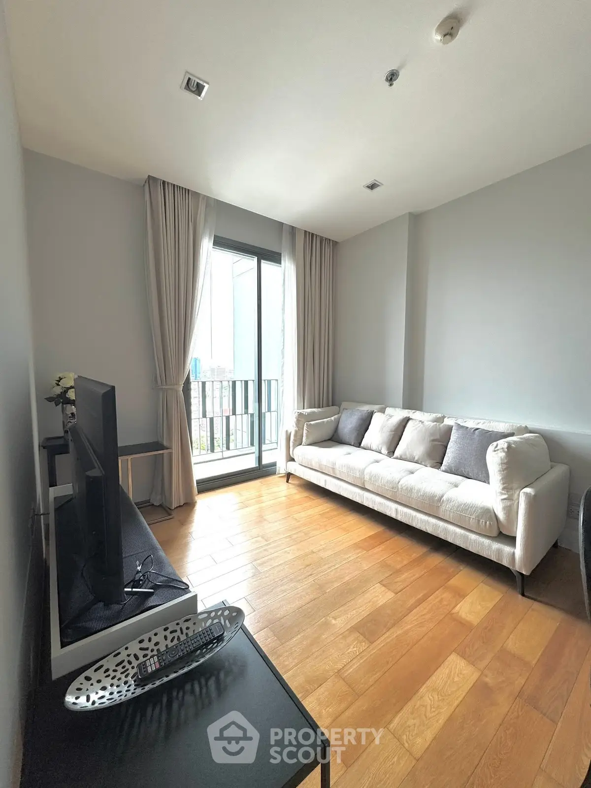 Modern living room with large window and cozy sofa in a high-rise apartment