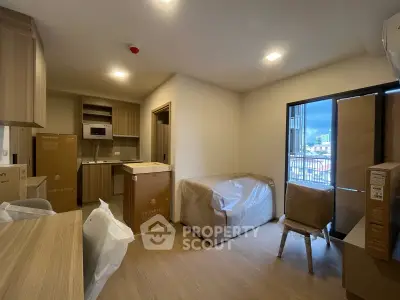 Modern apartment interior with open kitchen and balcony view, featuring new furniture and appliances.