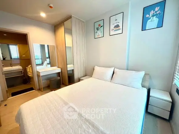 Modern bedroom with cozy decor and ensuite bathroom in a stylish apartment.