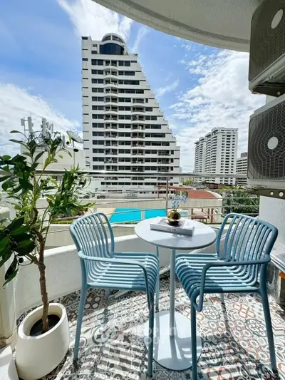 Chic balcony with stylish seating and stunning city view, perfect for relaxation and enjoying urban living.