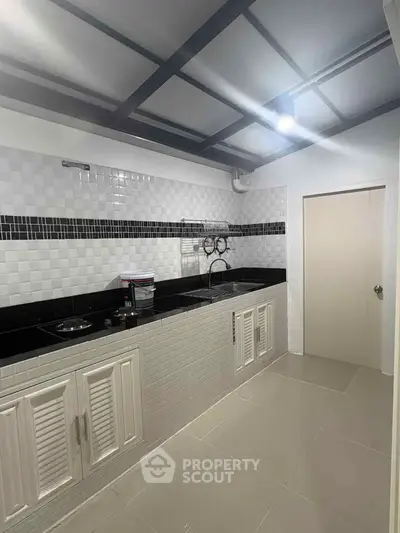 Modern kitchen with sleek black countertops and white cabinetry