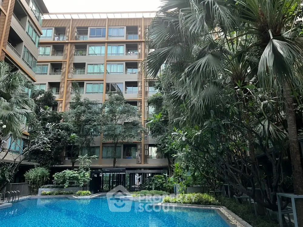 Luxurious residential building with a stunning pool and lush greenery, offering a serene urban oasis.