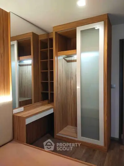 Modern bedroom with stylish wooden wardrobe and built-in shelves