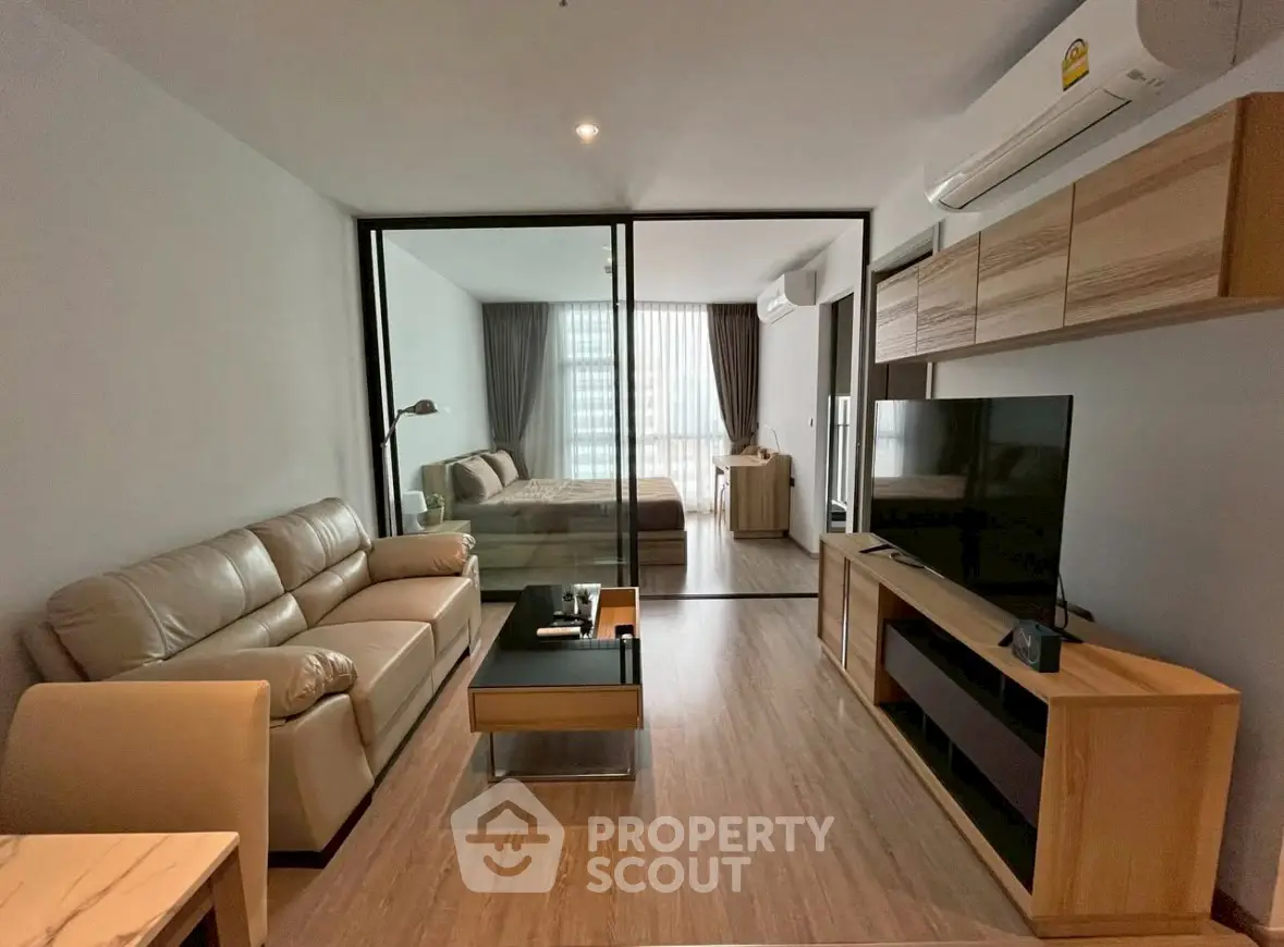 Modern living room with glass partition and cozy bedroom view