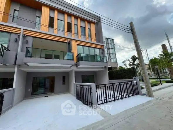 Modern multi-story townhouse with spacious balcony and sleek exterior design.