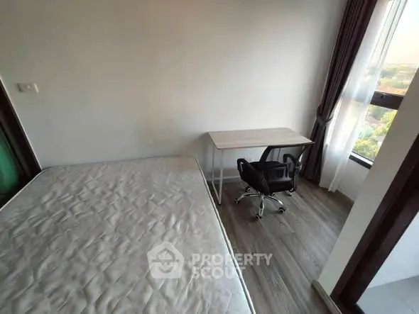 Cozy bedroom with natural light and workspace, perfect for urban living.