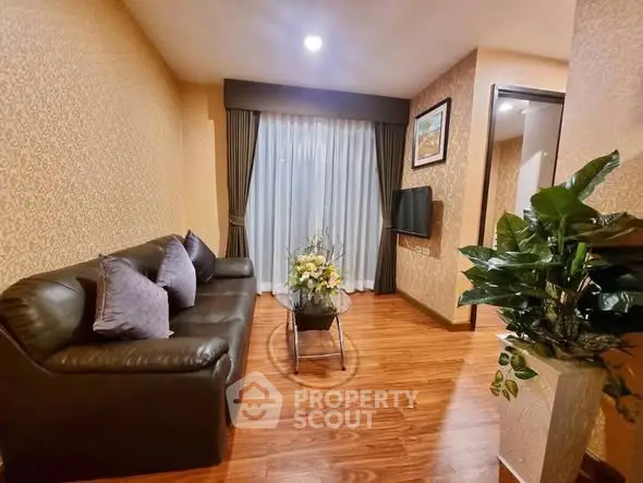 Cozy living room with elegant decor and wooden flooring, featuring a comfortable sofa and stylish curtains.
