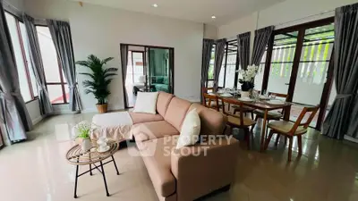 Spacious living room with elegant dining area and large windows in modern home