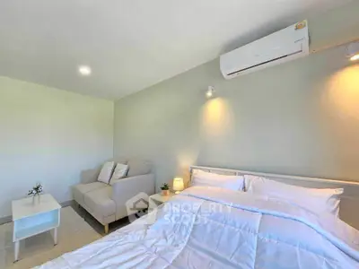 Modern bedroom with cozy bed, stylish sofa, and air conditioning for ultimate comfort.