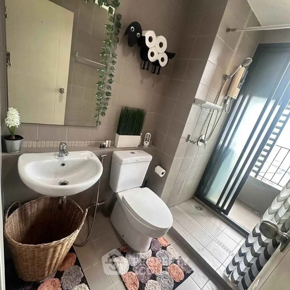 Modern bathroom with stylish decor and balcony access, featuring a shower and elegant fixtures.