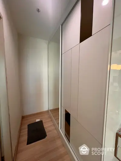 Modern hallway with sleek built-in storage and wooden flooring