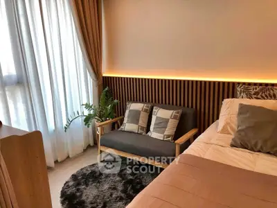 Cozy bedroom with modern decor, featuring a stylish sofa and ambient lighting.