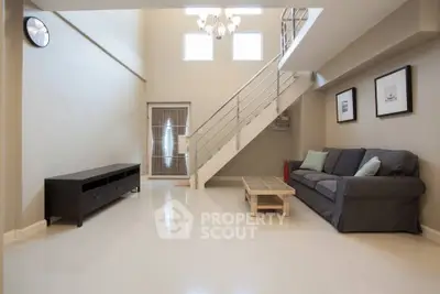 Spacious modern living room with high ceiling and stylish staircase