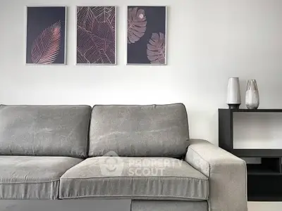 Modern living room with stylish grey sofa and elegant wall art