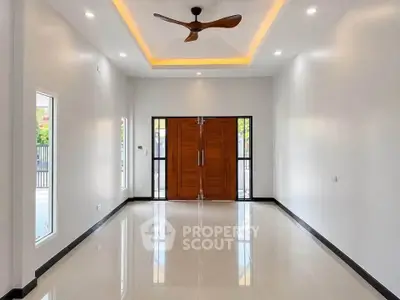 Spacious modern living room with elegant ceiling fan and large wooden doors