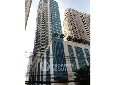 Stunning high-rise building with modern architecture and lush rooftop greenery in urban setting.