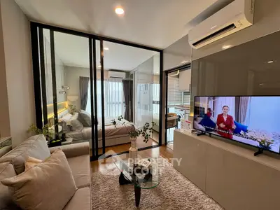 Modern living room with glass partition and cozy bedroom view