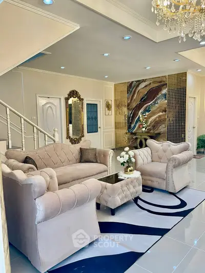 Luxurious living room with elegant sofas, stylish decor, and a chic chandelier, perfect for sophisticated living.