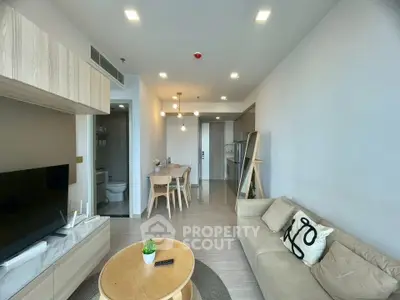 Modern living room with cozy sofa and dining area in open layout apartment.